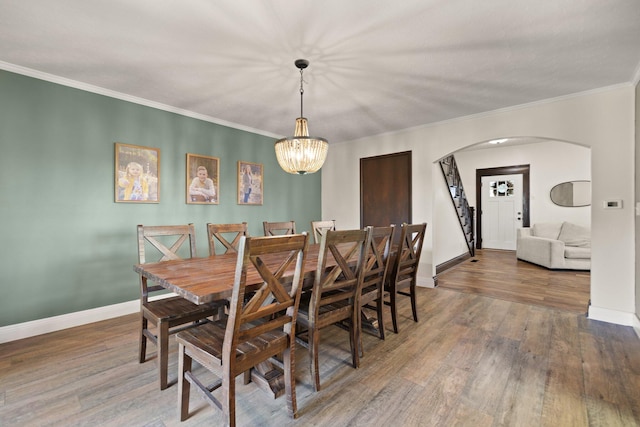 dining room featuring ornamental molding, a notable chandelier, and dark hardwood / wood-style flooring