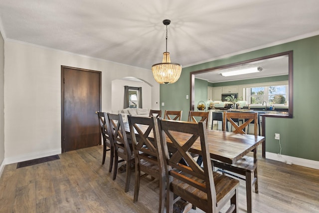 dining room with crown molding and dark hardwood / wood-style flooring