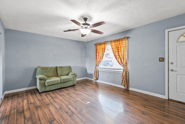 sitting room featuring dark wood-type flooring and a textured ceiling