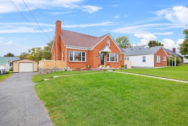 view of front of home featuring a front yard, a garage, and an outdoor structure