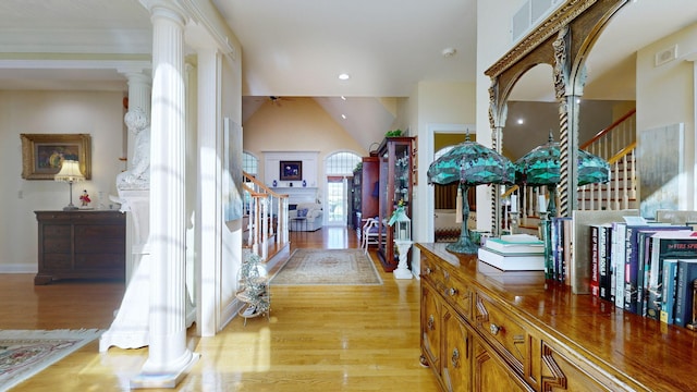 hallway with vaulted ceiling, ornate columns, and light hardwood / wood-style floors