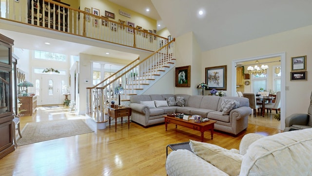 living room featuring a chandelier, a high ceiling, and light hardwood / wood-style floors