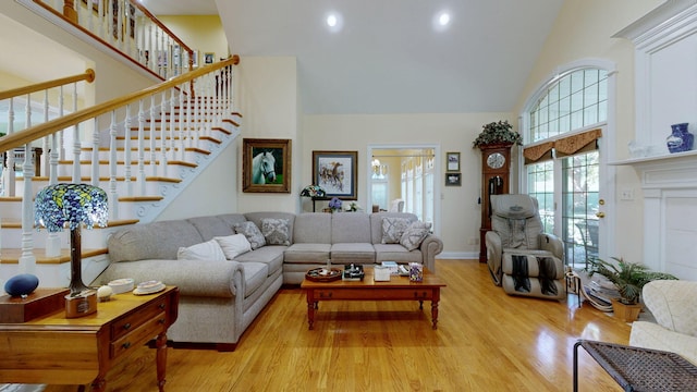 living room with light hardwood / wood-style flooring and high vaulted ceiling