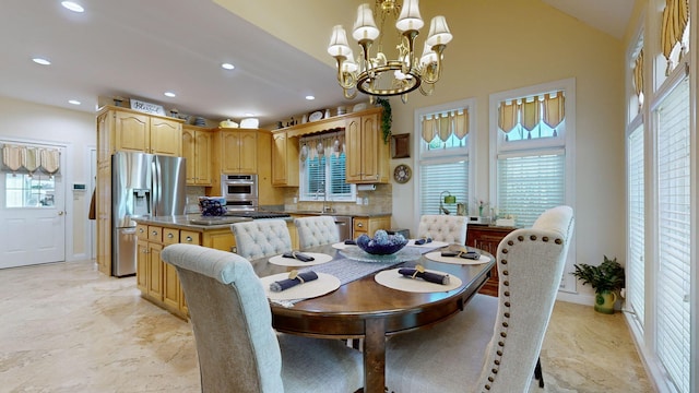 dining room featuring a notable chandelier, sink, and lofted ceiling