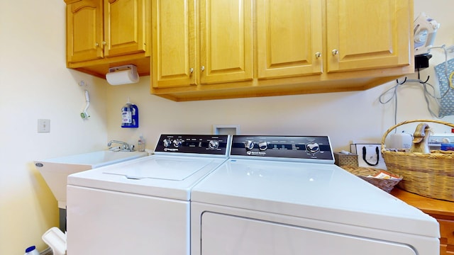 laundry room with washing machine and dryer and cabinets