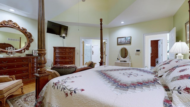 bedroom with ensuite bath and wood-type flooring