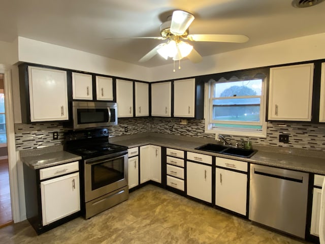 kitchen featuring appliances with stainless steel finishes, white cabinetry, sink, and backsplash