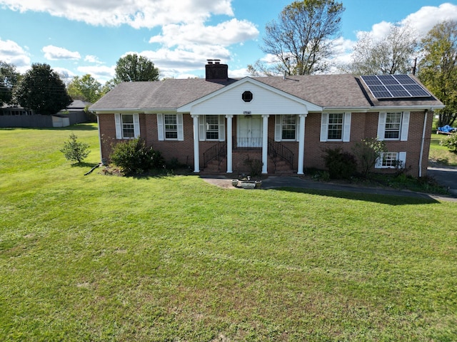 ranch-style home featuring solar panels, a front lawn, and a porch