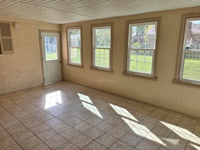 unfurnished sunroom featuring wood ceiling and a wealth of natural light