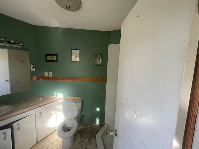 bathroom with tile patterned flooring, radiator, vanity, and toilet