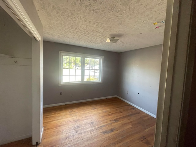 unfurnished bedroom with hardwood / wood-style flooring and a textured ceiling