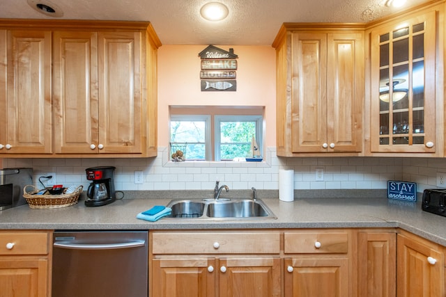 kitchen featuring stainless steel dishwasher, sink, decorative backsplash, and a textured ceiling