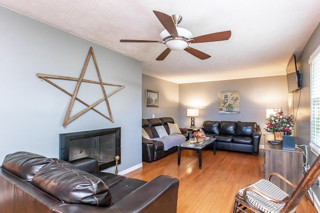 living room featuring a textured ceiling, hardwood / wood-style flooring, and ceiling fan