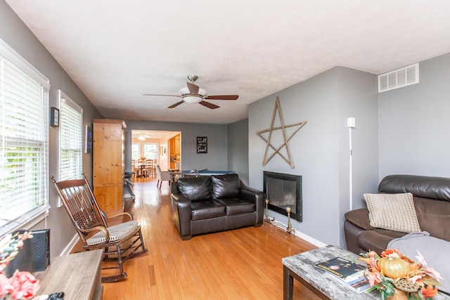 living room featuring light hardwood / wood-style floors and ceiling fan