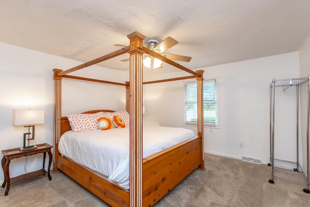 carpeted bedroom with a textured ceiling and ceiling fan