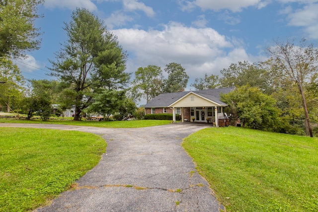 ranch-style home featuring a front lawn and a carport