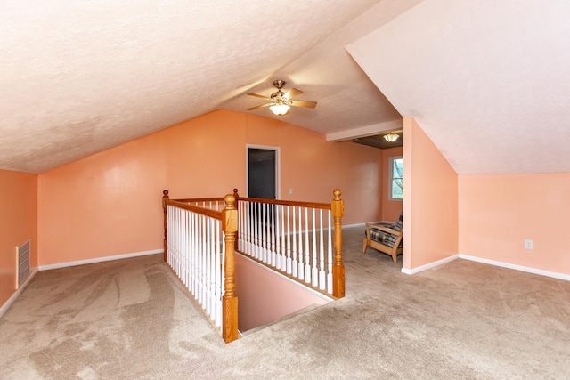 additional living space with lofted ceiling, a textured ceiling, carpet floors, and ceiling fan