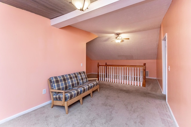 living area with light carpet, lofted ceiling with beams, and ceiling fan