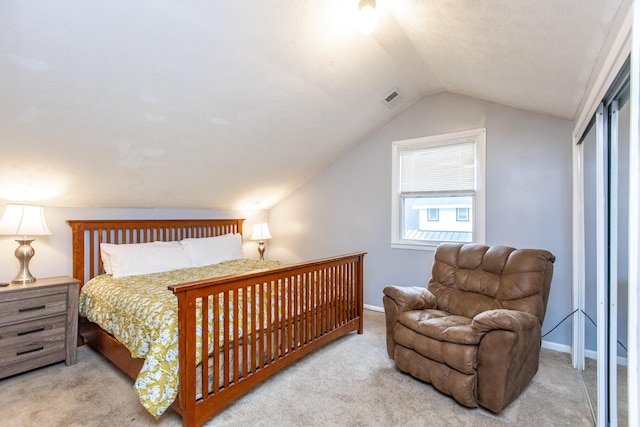 bedroom featuring vaulted ceiling and light colored carpet