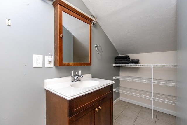 bathroom with vanity, tile patterned floors, and vaulted ceiling