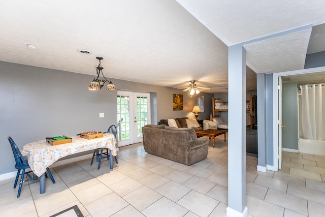 tiled dining space featuring french doors, a textured ceiling, and ceiling fan with notable chandelier