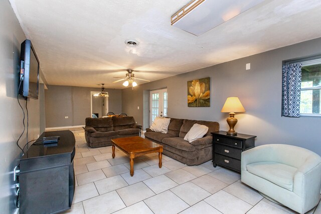 tiled living room featuring a textured ceiling, a healthy amount of sunlight, and ceiling fan