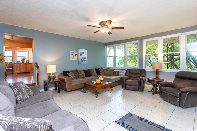 tiled living room featuring ceiling fan, a textured ceiling, and plenty of natural light