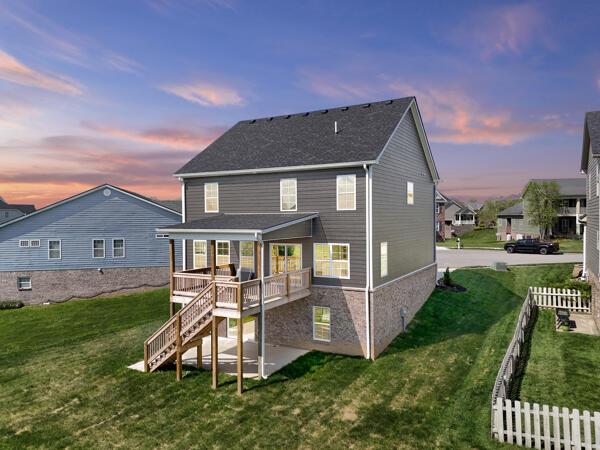 back of house with a deck, fence, a yard, and stairs