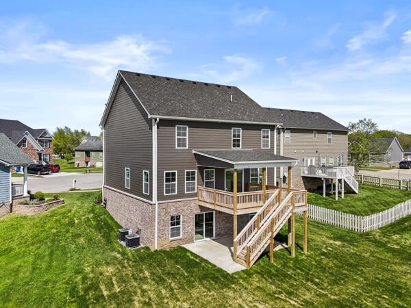 back of house featuring a lawn, a wooden deck, a fenced backyard, and stairs