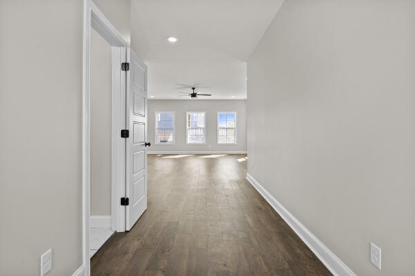 corridor featuring baseboards, recessed lighting, and dark wood-style flooring