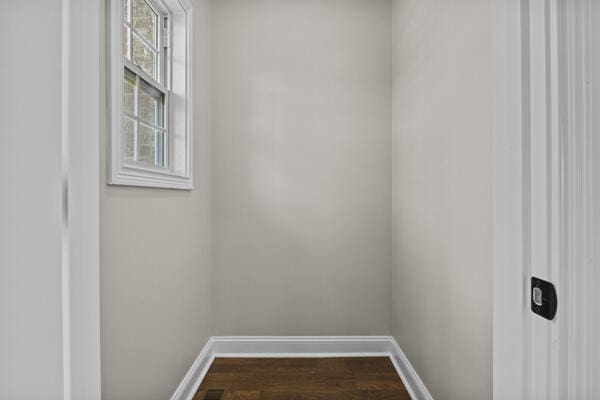 unfurnished room with dark wood-style floors and baseboards