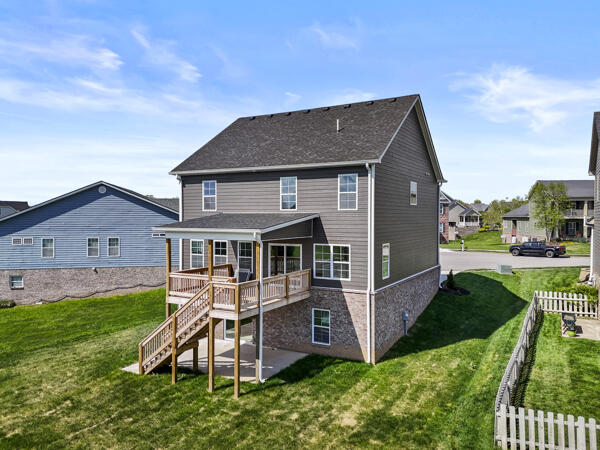 back of house featuring a deck, stairway, fence, and a yard