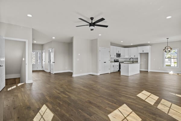 unfurnished living room with baseboards, recessed lighting, a ceiling fan, and dark wood-type flooring