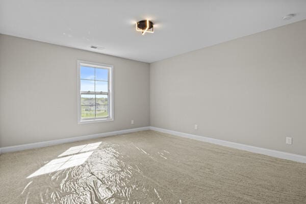 carpeted spare room featuring baseboards