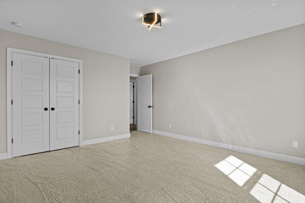 unfurnished bedroom featuring a closet, carpet flooring, and baseboards