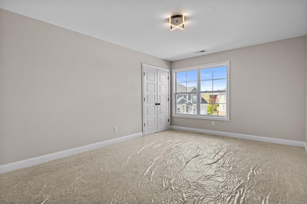 carpeted empty room with baseboards