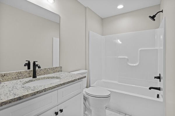 full bath with shower / bathing tub combination, marble finish floor, toilet, and vanity