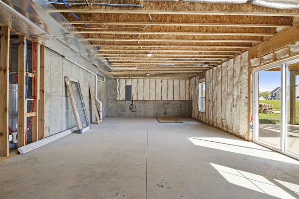 misc room with unfinished concrete floors and electric panel
