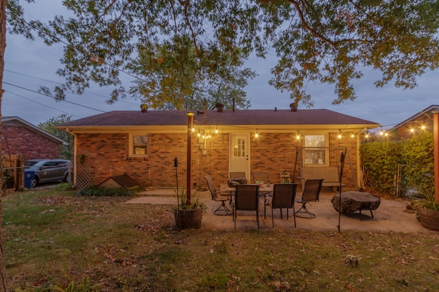 back house at dusk featuring a patio area