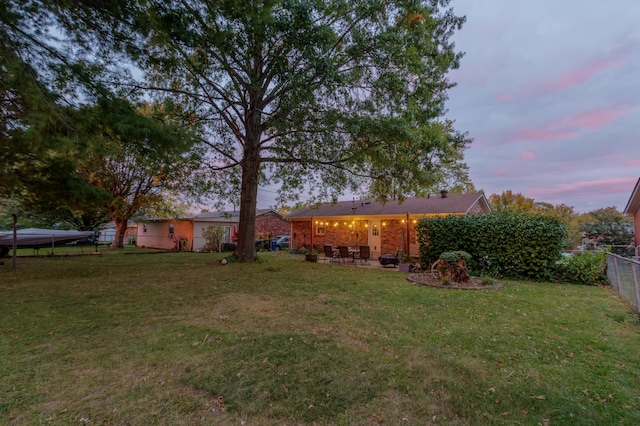 yard at dusk featuring a patio