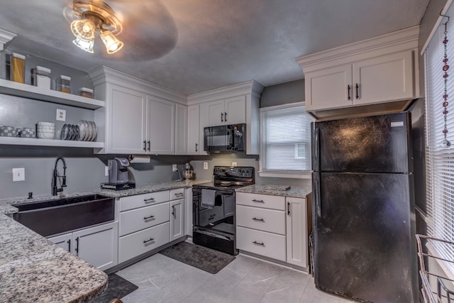 kitchen with white cabinetry, black appliances, sink, and a wealth of natural light