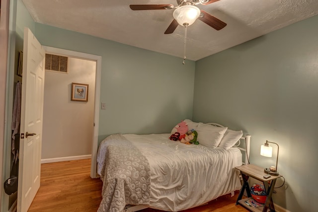 bedroom with light hardwood / wood-style flooring and ceiling fan