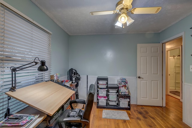 office space with a textured ceiling, hardwood / wood-style flooring, and ceiling fan