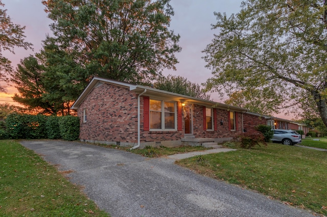 ranch-style home with a lawn