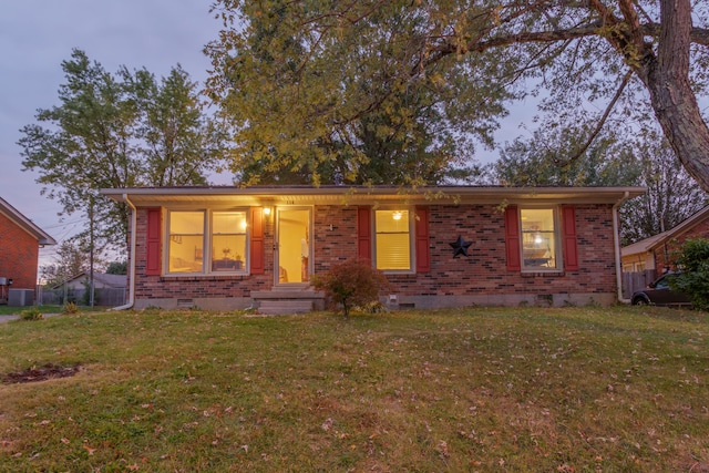 ranch-style home with a yard, a porch, and central AC unit