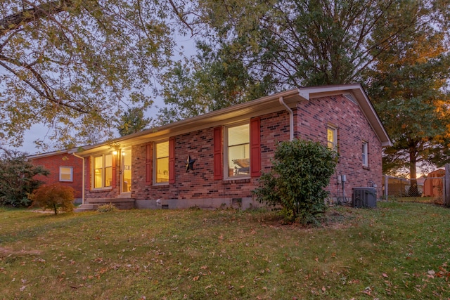 ranch-style home with a front yard and cooling unit