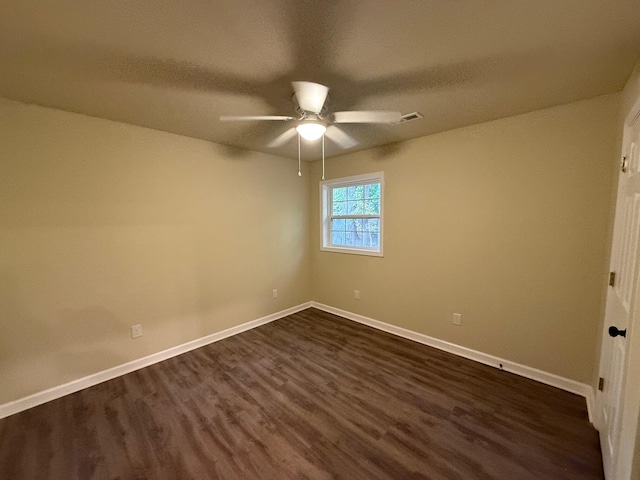 empty room with ceiling fan and dark wood-type flooring