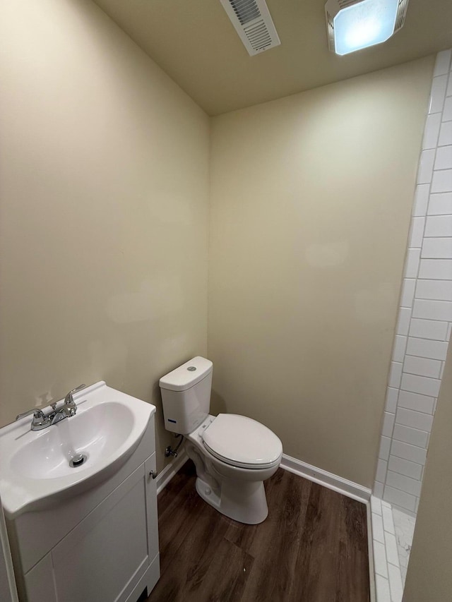 bathroom featuring a shower, hardwood / wood-style floors, vanity, and toilet