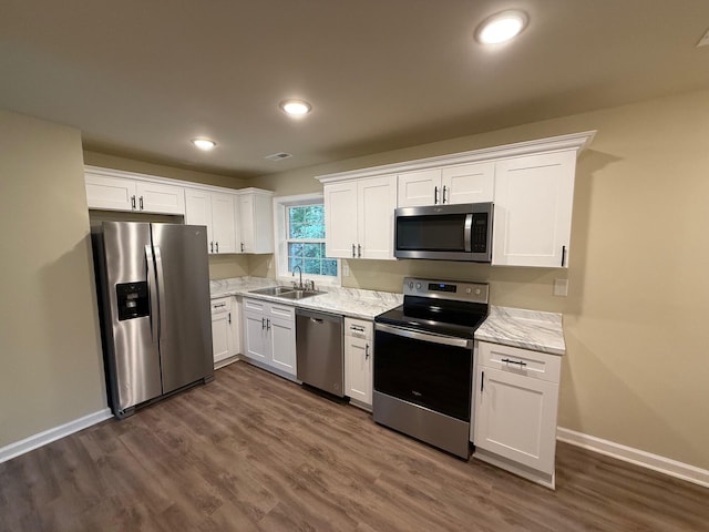 kitchen featuring white cabinets, sink, light stone countertops, and stainless steel appliances