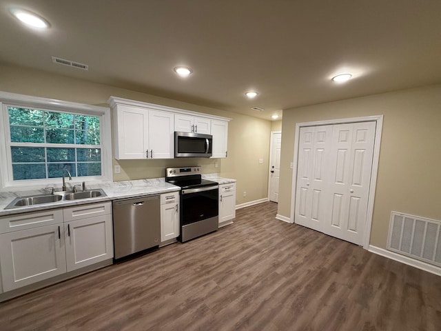 kitchen with dark hardwood / wood-style floors, sink, white cabinetry, and stainless steel appliances